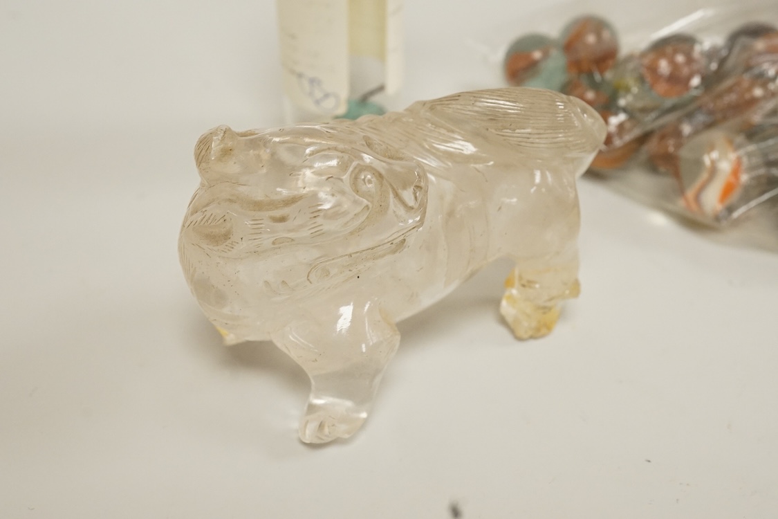 A Chinese carved rock crystal lion, a turquoise bead and a small quantity of marbles, lion 8.5cm wide